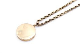 A 9ct gold locket and chain. The round locket 1.