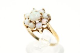 A 9ct gold and opal cluster ring. The central cabochon circa 5.