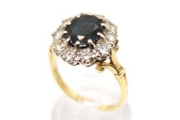 An 18ct carat gold cluster ring. Set centrally with one oval cut sapphire of 2.