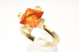 A large 14ct gold and synthetic gemstone dress ring. The central faceted stone 1.