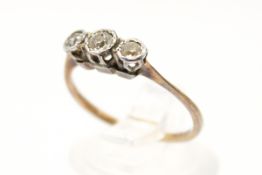 A yellow metal three stone diamond ring.