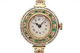 A diamond and emerald decorated cocktail watch.