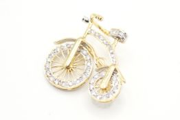 An articulated brooch in the form of a penny farthing. Set with round brilliant cut diamonds of 0.