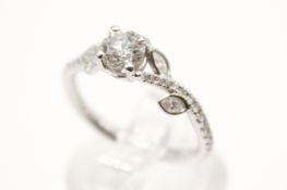 A platinum and diamond ring. The central round brilliant cut diamond of circa 0.
