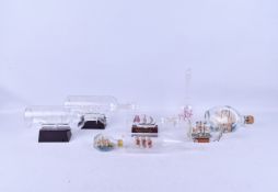A collection of eight assorted model ships in a bottle.