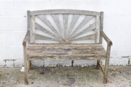 A 20th Century weathered teak garden bench with sunray effect slat back and slat seat.
