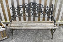 A 20th Century decorative cast metal bench with wooden slat seat.