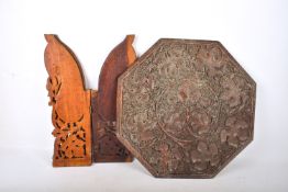 An Indian carved hardwood folding table. The octagonal top with grape and vine decoration.