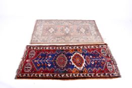 Two 20th Century rugs. One on a cream and pick ground, L134 x W79cm.