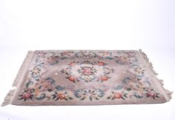 A Chinese style wool rug on a cream ground. Having stylized floral borders and medallion.