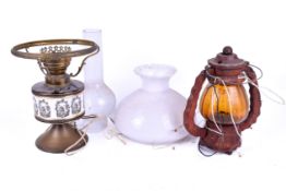 Two converted oil lamps. Including a brass example with white shade and a chimney, etc.