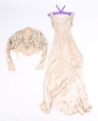 A vintage evening outfit comprising of a cream dress and matching jacket.