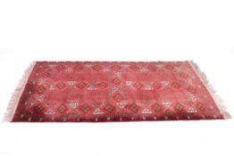 A 20th Century red ground rug with geometric pattern.