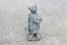 A modern moulded resin garden statue of a boy carrying urn and flowers.