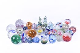 A large quantity of vintage glass paper weights.