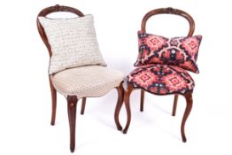 A Pair of Victorian balloon back chairs with carved back rests.