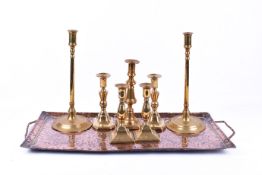 A 'John Pearson' copper tray along with three pairs of brass candle sticks and another.