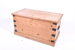 A vintage pine trunk with metal brackets and handles.