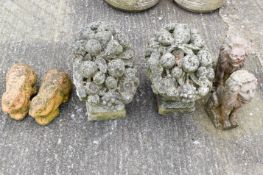 A pair of reconsituted stone garden ornaments in the form of fruit baskets,