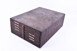 A quantity of brass printers blocks in a wooden six drawer case.