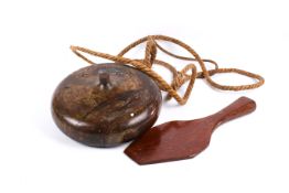 A large wooden 'gasing' or spinning top from Malaysia with rope and paddle.