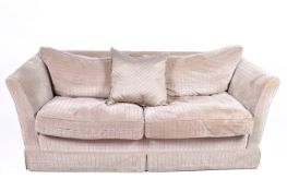A contemporary low back two seater sofa. Having textured upholstery with feather filled cushions.
