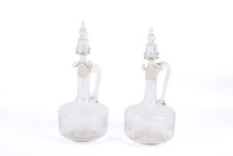 A pair of glass carafes with stoppers.
