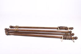 Four hardwood curtain poles with brass wall fittings and curtain hoops.