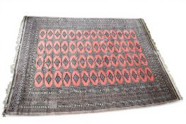 A Bokhara, antique pink and grey ground rug with geometric pattern.