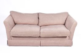 A contemporary two-seater low back sofa with spot pattern upholstery. Having feather cushions.