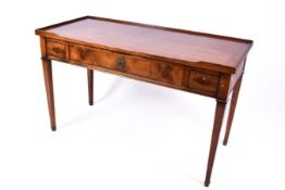 A 20th century Georgian style oak writing table or desk with three drawers.