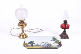 An oil lamp and oil style table lamp along with a vintage painted wall mirror with bevel edge.