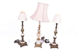 A pair of mid-century gilt brass and stone table lamps with a larger similar example.