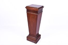 A 20th Century tapered mahogany pedestal stand with carved detail.
