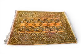 A vintage orange and black ground rug with geometric pattern.