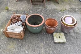 Six medium sized terracotta and terracotta style garden pots including one green glazed,