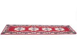 A modern red ground runner rug.