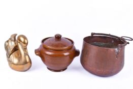 A copper pot, a brass 'swan' bookends and a earthenware storage jar with cover.