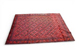 A large Afghan rug. Red groundw ith blue geometric pattern.