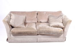 A contemporary low back two seater sofa. Having textured upholstery with feather filled cushions.