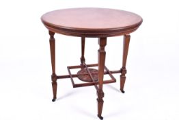 A Victorian walnut circular centre table having ornate cross stretcher and under tier,