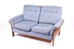 Modern 2 seater bergere style sofa with light blue upholstered cushions.