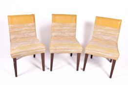A set of three contemporary dining chairs.
