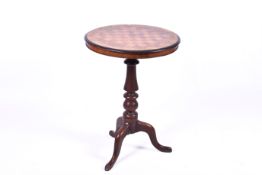 A Victorian walnut circular games table (top spilt) on tripod base.