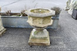A large reconstituted stone octagonal urn on a square base and a plinth.