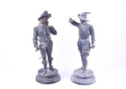 Pair of spelter figures modelled as gentleman bearing swords. Raised on circular base.