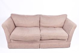 A contemporary two-seater low back sofa with spot pattern upholstery. Having feather cushions.