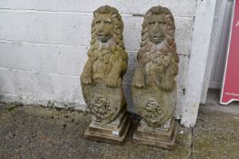 A large pair of reconstituted stone lions with shields. H83cm.