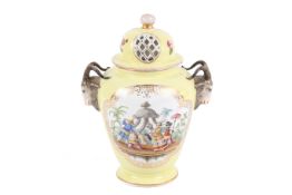 A Dresden style yellow porcelain urn with pierced lid.