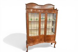 1920s mahogany display cabinet, fitted two bowed leaded glass doors, raised on cabriole supports.